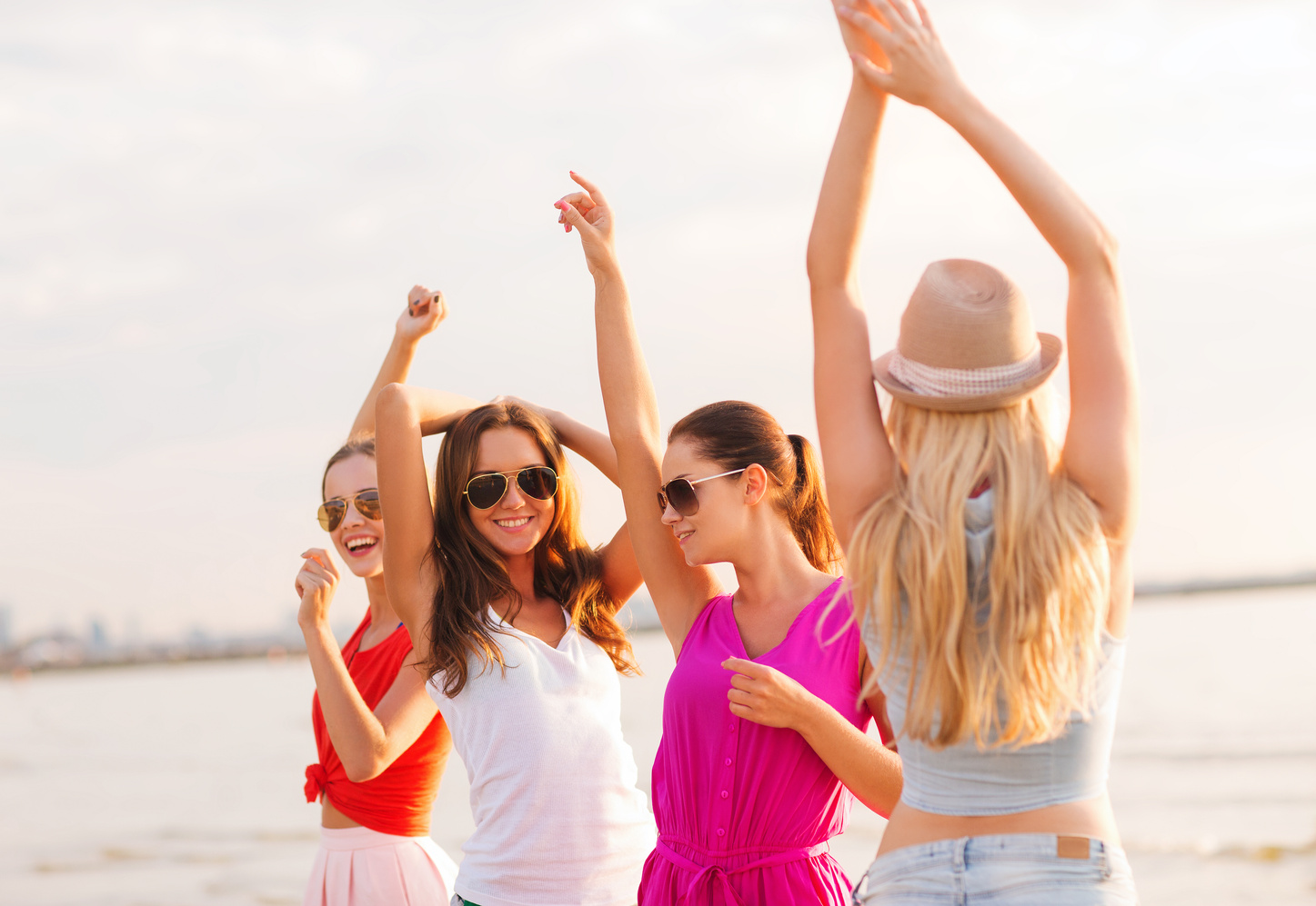 Group of Smiling Women Dancing on Beach